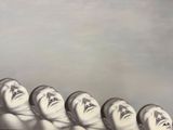 un tableau représentant un groupe de têtes sur lesquelles sont peints des visages