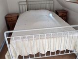un lit blanc dans une chambre avec une poutre en bois au plafond