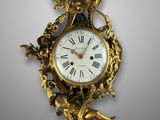 an antique clock with a bird on the back of it