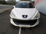 the front end of a white car parked in a parking lot
