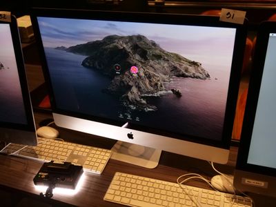 deux écrans d'ordinateur posés sur un bureau avec un clavier et une souris