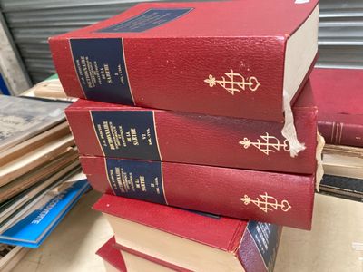trois livres rouges empilés les uns sur les autres sur une table