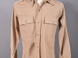 une photo d'une chemise beige sur un présentoir à mannequin