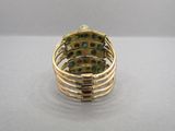 Gros plan sur une bague en or ornée de pierres vertes