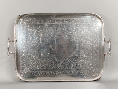 un plateau en argent sur lequel figure le portrait d'un homme