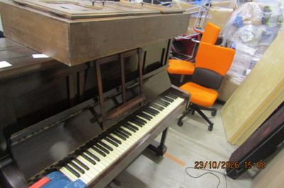 un piano et une chaise dans une pièce encombrée