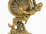 brass figurine of a man holding a wheel on a pedestal