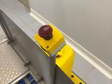 a yellow button on the side of a metal door