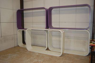 des étagères violettes et blanches dans une pièce carrelée de blanc, avec un sol en carrelage