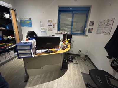 a desk with a computer and a chair in a room