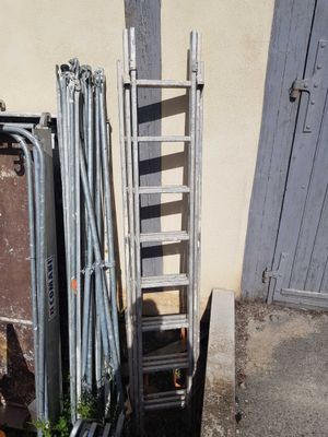a ladder leaning against a wall next to a pile of junk