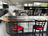 two red chairs sitting at the bar in the kitchen