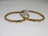 deux bracelets en or ornés de motifs gravés sur un fond blanc