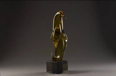 une statue en or représentant une femme debout sur un socle noir