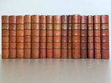 several old books lined up in a row on top of a table