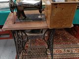 une table sur laquelle est posée une machine à coudre, dans une pièce