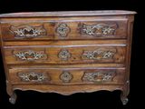 une vieille commode en bois avec des sculptures ornementales sur les tiroirs