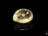 a close up of a yellow diamond on a black surface