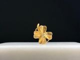 a close up of a gold flower ring on a white surface