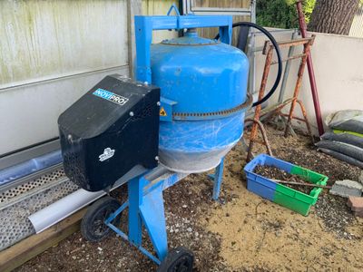 un réservoir bleu posé à côté d'une machine bleue dans une cour