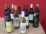 Des bouteilles de vin sont alignées sur une table devant un mur rouge.