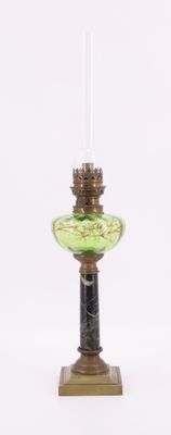 un bougeoir en verre vert sur lequel est posée une bougie