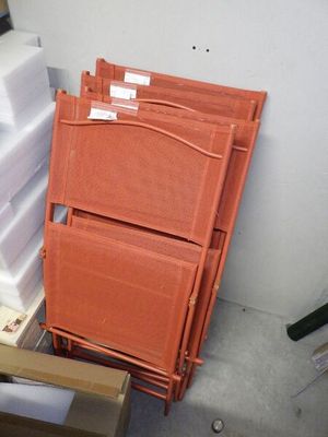 une pile de cartons et une pile de chaises dans une pièce