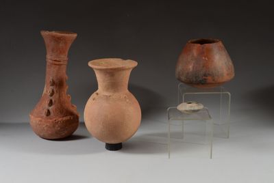 three vases are sitting on a table next to a chair