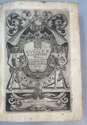un vieux livre avec une image en noir et blanc d'un blason
