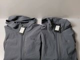 a pair of gray jackets sitting on top of a white table