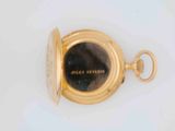a close up of a gold pocket watch on a white surface