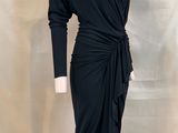 La robe est noire, elle a des manches longues et un cordon à nouer à la taille.