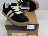 pair of black and gold sneakers sitting on top of a cardboard box
