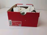 a red box with a pair of white shoes in it