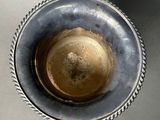 a silver bowl with a rope around it on a table