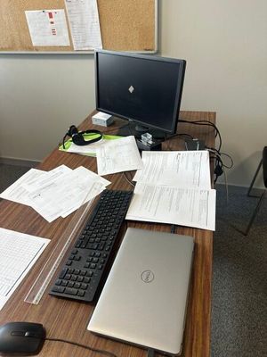 un bureau sur lequel se trouvent un ordinateur, un clavier, une souris et des papiers