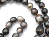 a long strand of black pearls on a white surface