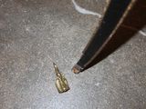 a small piece of metal on the ground next to a pair of scissors