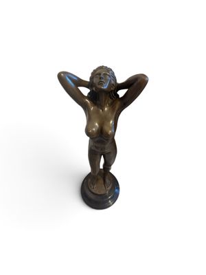 bronze statue of a woman holding her hands on her head