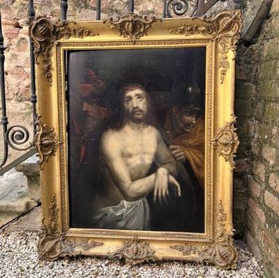 tableau représentant Jésus, dans un cadre doré, accroché à un mur de pierre
