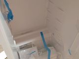 a white refrigerator with blue tape taped to it ' s door