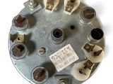 an overhead view of a round metal device with several screws and nuts