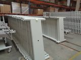many white radiators in a warehouse with pallets on the floor