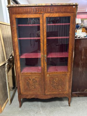 un meuble en bois avec des portes en verre dans une pièce