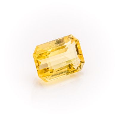 a yellow sapphire stone on a white background
