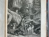 an old book with a picture of a man and dogs on it