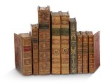 plusieurs vieux livres empilés sur une surface blanche