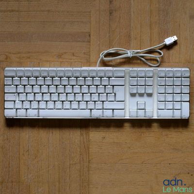 un clavier et une souris d'ordinateur posés sur une table en bois