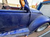 a blue truck that is parked on the side of the road