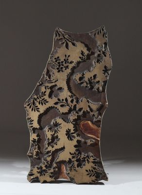 une image représentant un vase orné d'un motif, posé sur une surface blanche